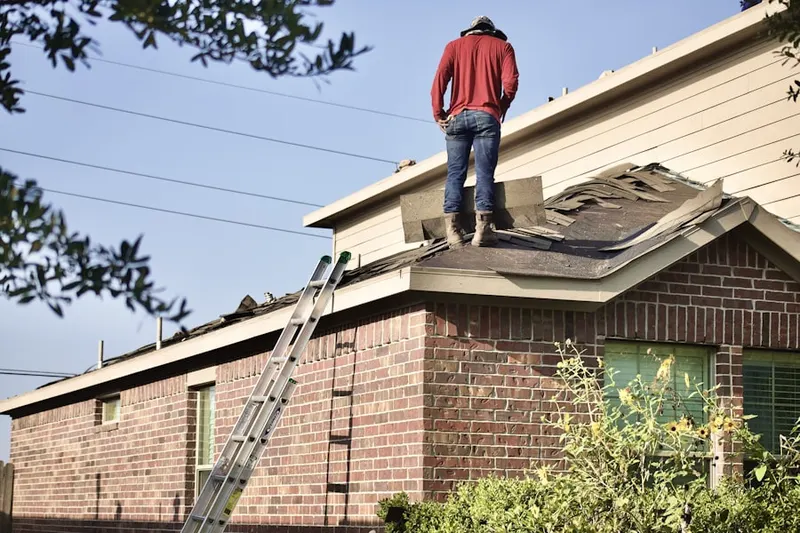 Professional roofer working on a residential roof in Dans